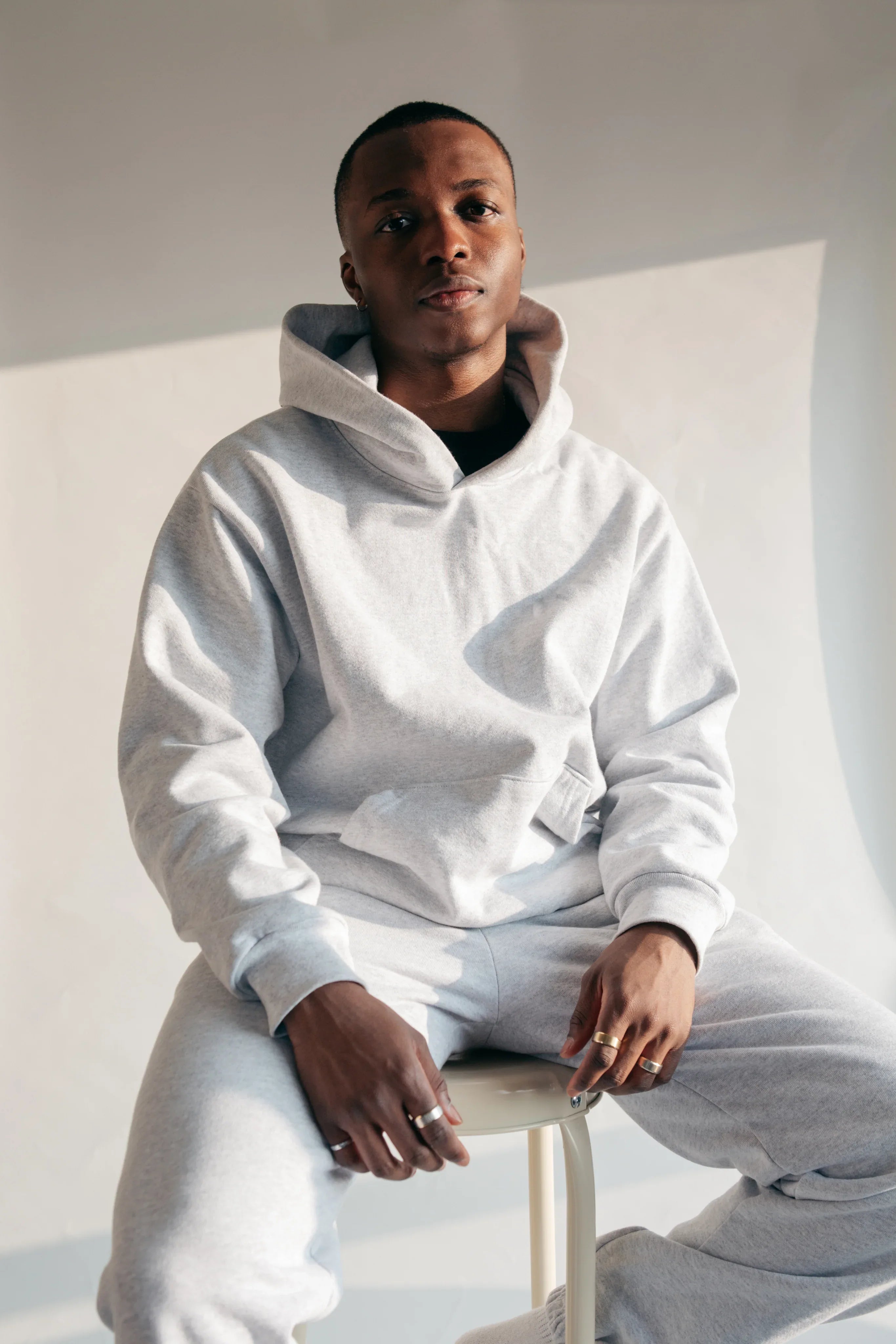 man-on-stool-in-hoodie-and-sweatpants - SHIRT & CANVAS